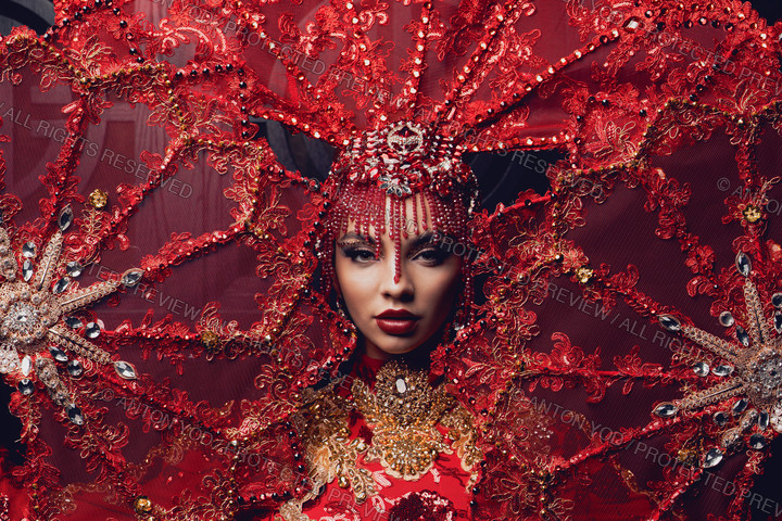 Model in an ornate red ceremonial costume, photographed by Anton Yod.